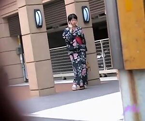 Zwartharige kleine geisha flitst met haar tieten als iemand haar outfit aantrekt