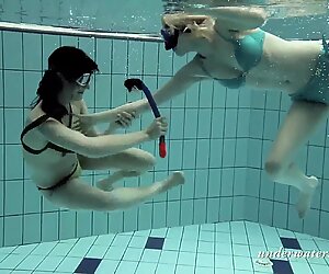 Tytöt uinti vedenalainen ja toisistamme nauttiminen